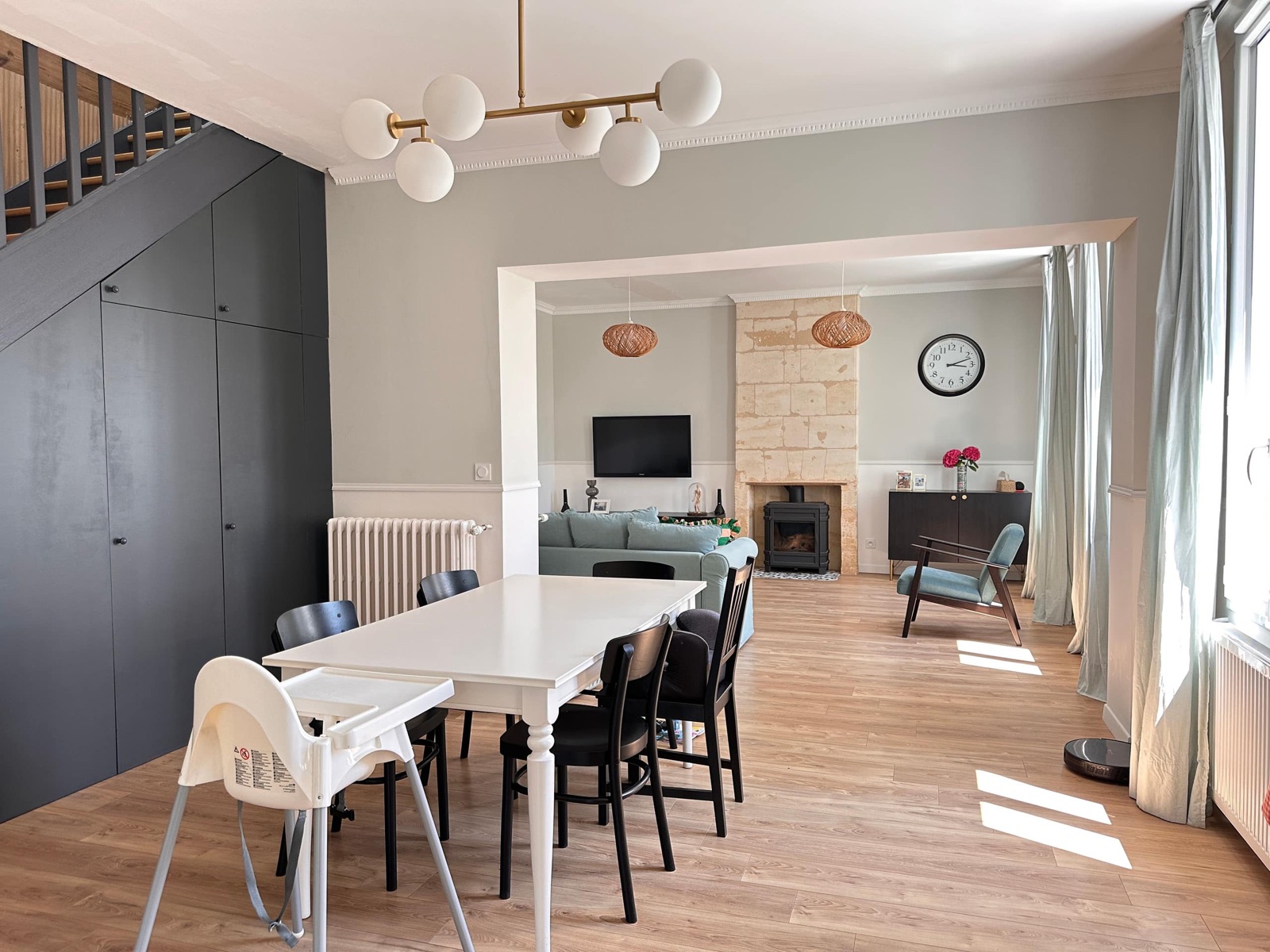 Séjour lumineux d’un appartement aménagé par STAYNEST, avec salle à manger, salon et cheminée